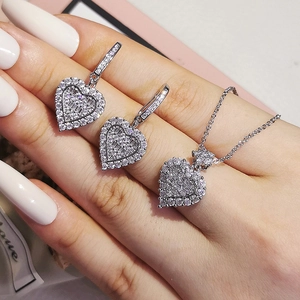 Funkelndes silbernes Herz-Schmuckset mit Halskette und Ohrringen in der Hand