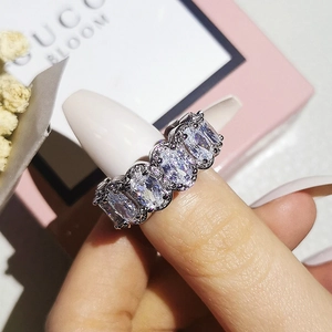 Close-up of sparkling oval-cut zircon wedding ring set in silver on hand