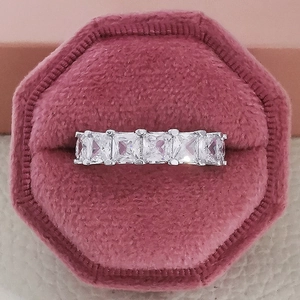 Detailed close-up of a silver ring with five square-cut zircons in a pink velvet box