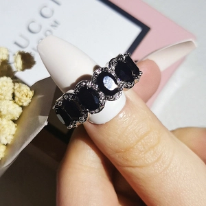 Close-up of vintage oval black zircon ring with halo diamond setting on hand