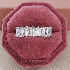 Macro view of rectangular cut cubic zirconia stones set in a silver eternity ring band