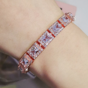 Close-up of rose gold bracelet with rectangular zircon stones in halo setting