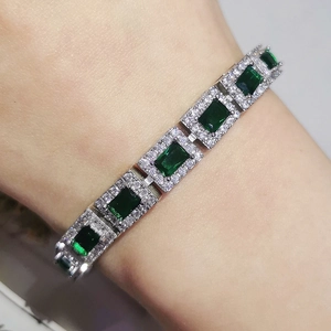 Macro detail of silver plated bracelet featuring emerald cut green stones and zircons