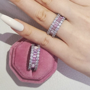 Détail de bagues éternité avec zircons baguettes roses et pierres claires en boîte velours
