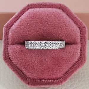 Anillo de eternidad plateado con cuatro filas de circonitas en una caja de terciopelo rosa