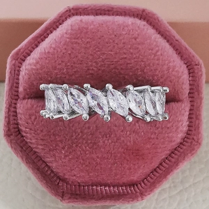 Detail of silver marquise-cut zirconia ring in a pink velvet box on leather background