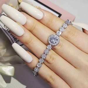 Sparkling silver halo bracelet with cubic zirconia on a wrist near a pink gift box