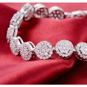 Luxury silver-toned circular link bracelet with sparkling cubic zirconia on red silk fabric