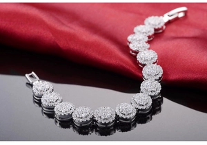 Detailed close-up of 18K silver bracelet with clusters of micro-set zircon stones