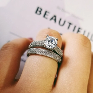 Detalle del conjunto de anillos de boda de doble capa con piedra central y diamantes micropavé