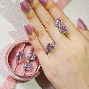 Pink cushion-cut jewelry set with earrings and rings displayed in a velvet gift box