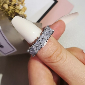 On-hand view of a silver ring with triangular cubic zirconia in a full row setting