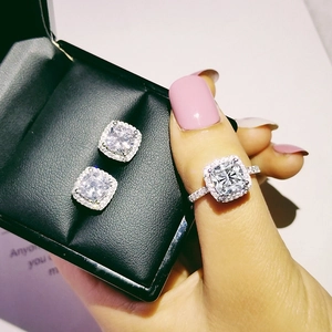 Detail view of cushion-cut halo jewelry set with sparkling stones on silver band