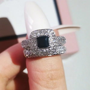 Detail view of a luxury bridal ring set featuring a black square gem and pavé diamonds