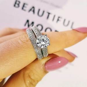 Primer plano de conjunto de anillos de boda con pavé de circonitas sobre una mano real