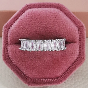 Macro shot of a luxury silver band ring with rectangular diamonds in a pink velvet box