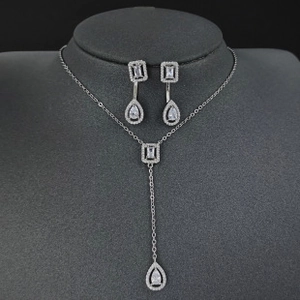 Close-up of luxury silver jewelry set featuring crystal necklace and drop earrings