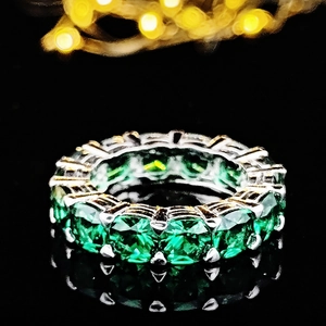 Bague éternité de luxe avec pierres précieuses vert émeraude en serti argent poli