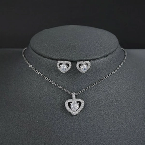 Detailed macro view of heart-shaped silver necklace and earrings set on display