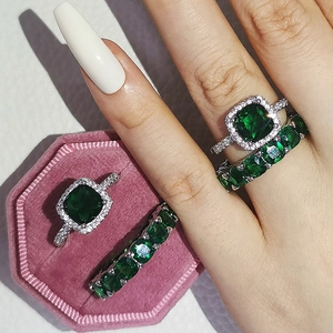 Vue macro de la bague halo en émeraude et anneaux d'éternité dans un écrin en velours