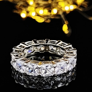 Vue macro d'une alliance éternité sertie de zircons carrés sur fond noir élégant