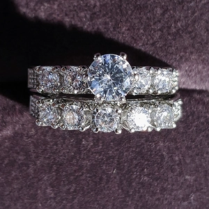 Detalle macro del conjunto de anillos de compromiso de plata sobre fondo de terciopelo