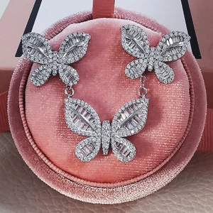 Macro detail of silver butterfly jewelry set with zircon stones in a pink velvet box