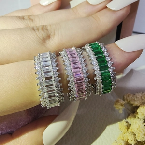Three-piece set of luxury zircon rings in white pink and green colors on finger