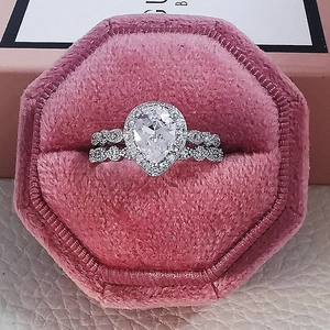Set de anillos de compromiso con circón de pera y halo en joyero de terciopelo rosa