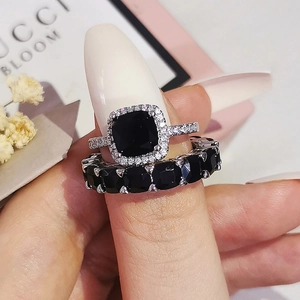 Gros plan de bagues empilables en argent avec pierre noire carrée et accents pavés