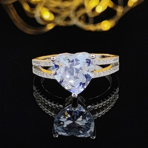 Macro shot of silver heart-shaped diamond ring with pavé stones and crystal reflection