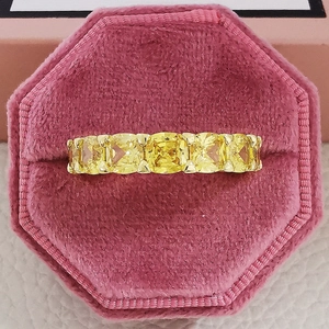 Vue macro de cinq pierres jaunes taille coussin dans un écrin en velours rose