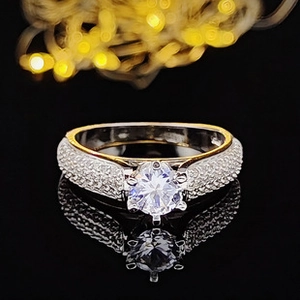 Macro view of six-prong silver ring with central zircon and pave diamond band