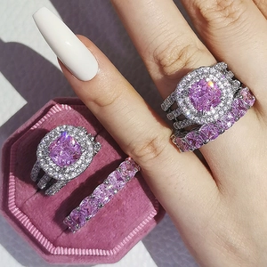 Détail d'un ensemble de bagues de mariage avec pierre rose et cristaux brillants