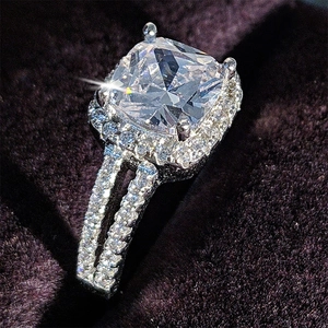 Dettaglio macro di anello di lusso con zircone taglio cushion e gambo diviso su velluto