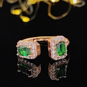 Details des offenen Rings in Roségold mit grünen Steinen im Smaragdschliff und Halo