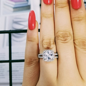 Primo piano di un anello di lusso con zircone quadrato, montatura halo e gambo diviso