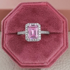 Macro shot of an emerald cut pink gemstone ring in an octagon velvet jewelry box
