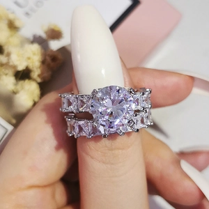 Gros plan d'un ensemble de bagues en argent avec pierres taille émeraude et cristaux zircons