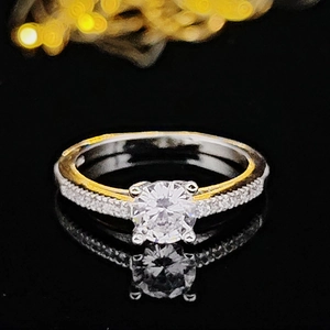 Anillo de diamante de corte redondo con detalles dorados sobre fondo negro reflectante