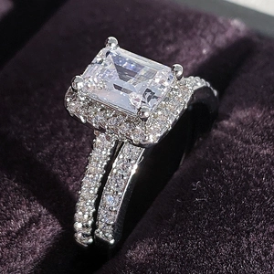 Sparkling rectangular zircon ring set with micro-pave diamonds in a purple velvet box