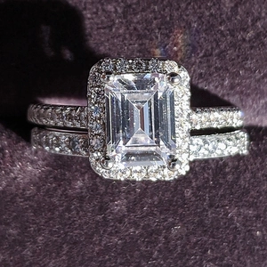 Fashionable emerald cut cubic zirconia halo ring with sparkling pavé band on velvet box