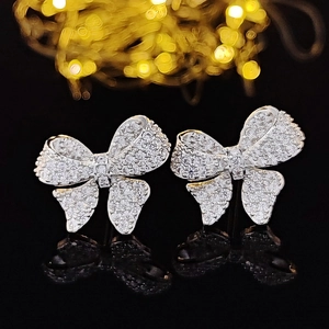 Sparkling silver butterfly stud earrings with zircon stones on a dark reflective background