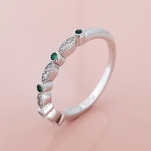 Gedetailleerd beeld van zilverkleurige ring met smaragdgroene zirkoon en micro-pave zetting