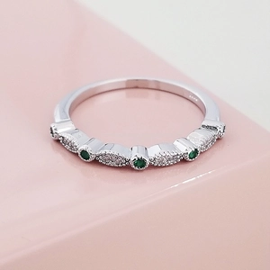 Detailopname van smaragd en witte zirkoonzetting met kralenrand op de zilveren ring