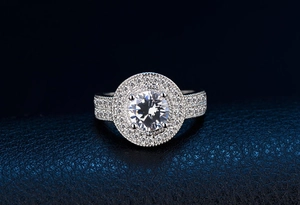 Nahaufnahme eines silbernen Halo-Rings mit doppelter Pavé-Fassung auf Leder