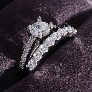 Elegante conjunto de dos anillos de compromiso con circón redondo en tono plata y caja de regalo