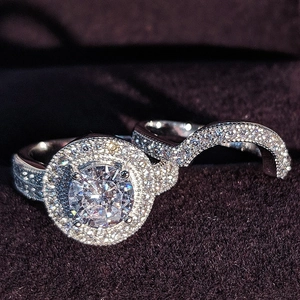 Lujoso set de anillos de plata con diamante redondo y pavé sobre terciopelo