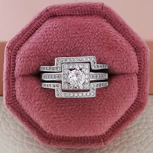 Lujoso set de anillos de novia plateados con piedra central y joyero de terciopelo rosa