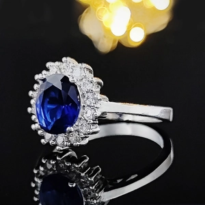 Luxurious silver halo ring featuring a large oval blue sapphire and sparkling diamonds